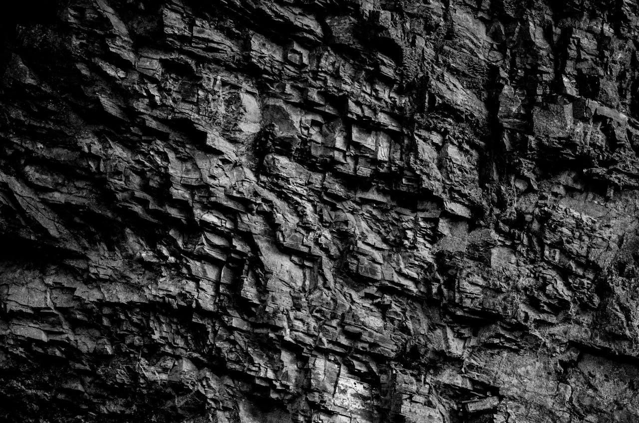 about-us-01 Grayscale close-up of a rocky surface showcasing intricate texture and pattern.